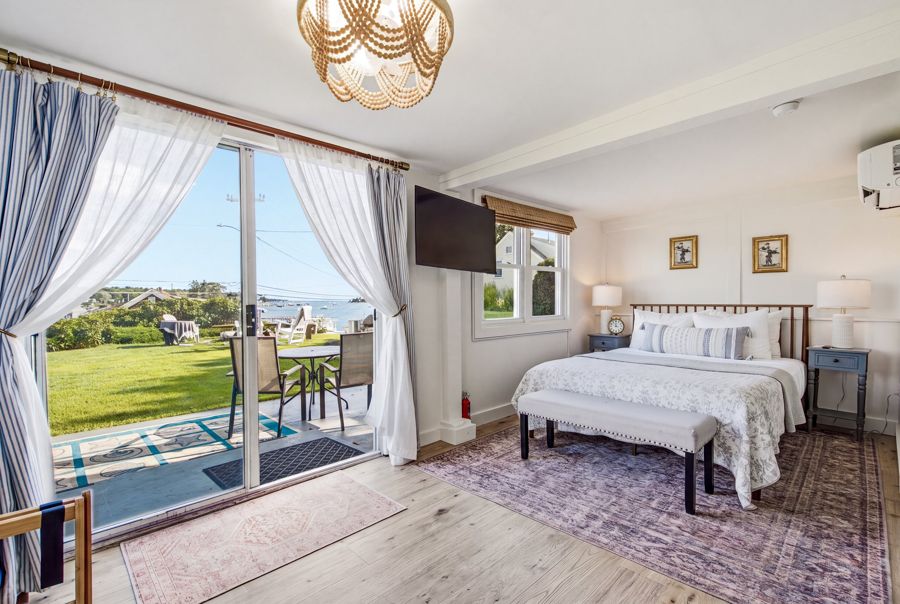 Queen bed with the sliding door open to the patio and the harbor