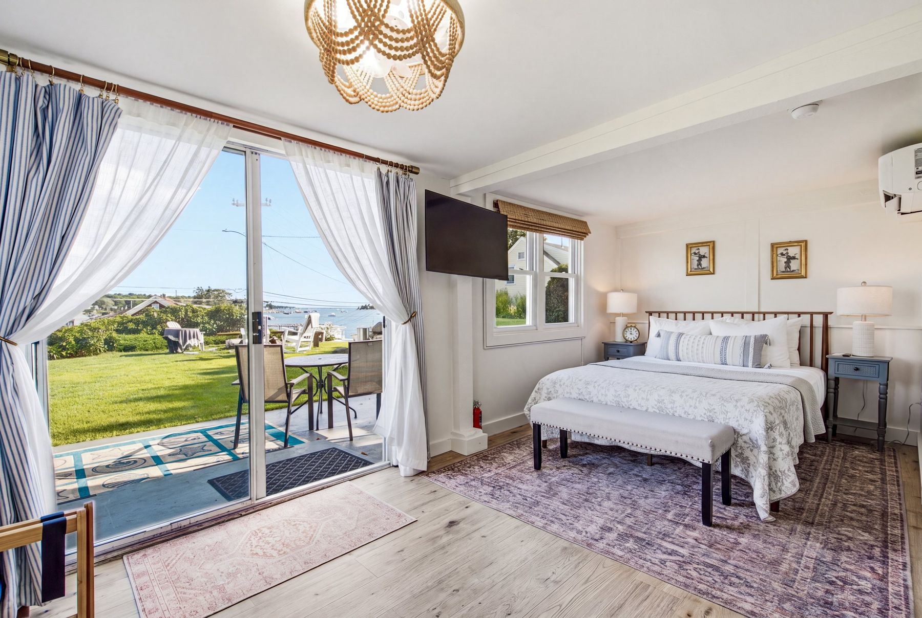 Queen bed with the sliding door open to the patio and the harbor